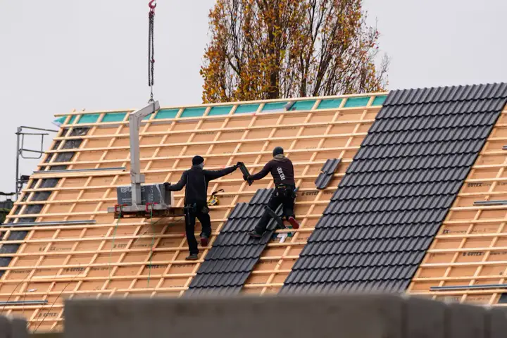 Dekarze kładą dachówkę na łatach